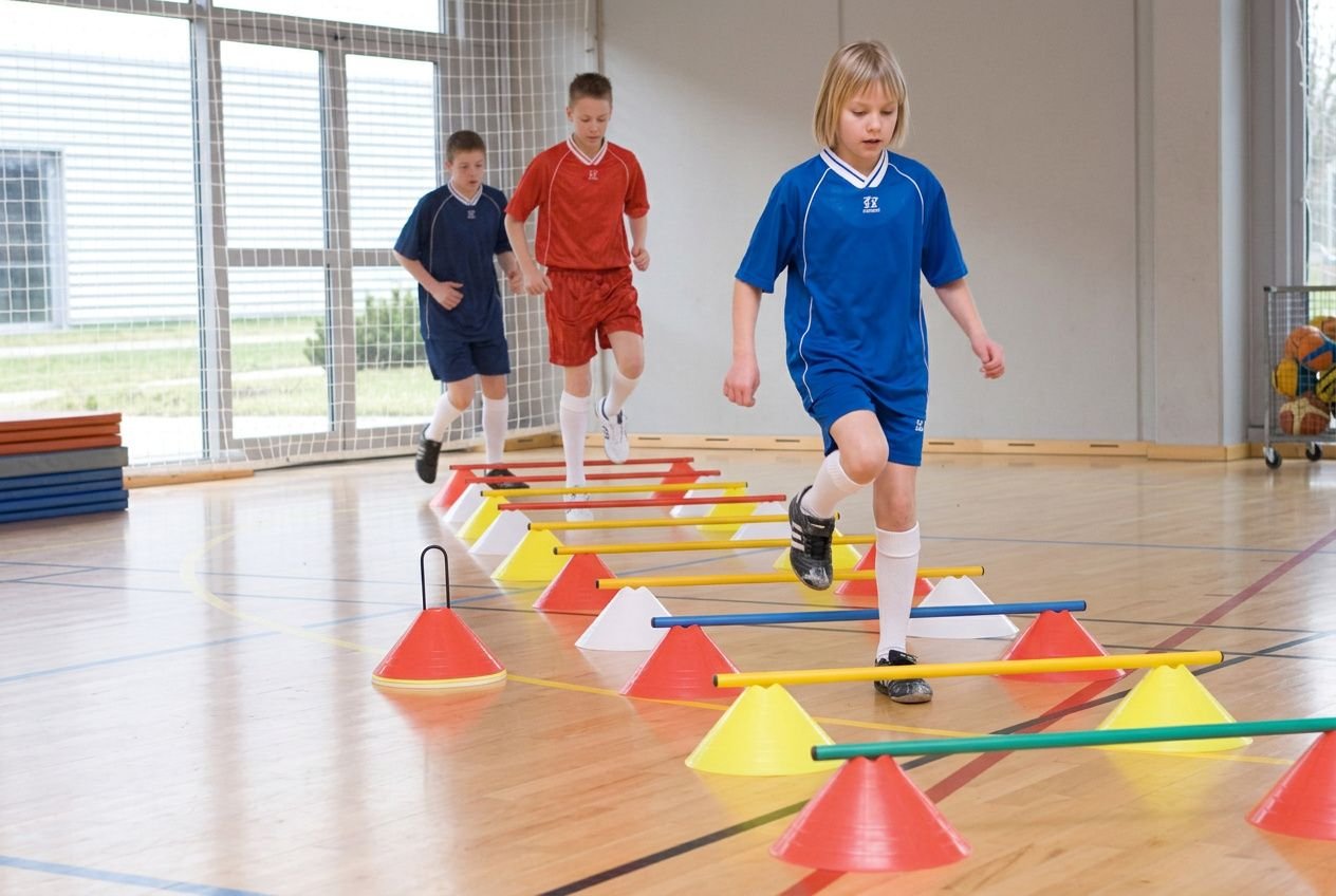 Kinderen oefenen grove motoriek met een pilonenset in een gymzaal.